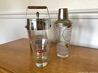Ice bucket, shaker, and Martini glass on table