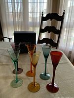 Set of six coloured cordial glasses with box on table
