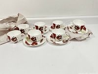Full set of eight teacups and saucers, some still partly wrapped