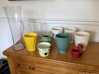 Full grouping of all glass vases and ceramic planters on dresser