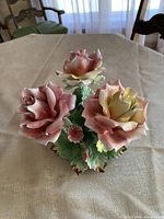 Front view of porcelain bouquet showing three large roses and smaller flowers