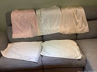 Five slips laid on sofa showing variety of colors and lace hems