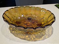Top view showing full oval bowl, scalloped rim, iridescent finish and fruit motif