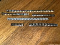 Seven Zoppini link strips laid out on table