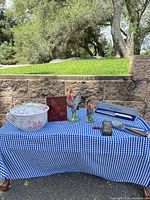 Full lot on blue gingham cloth including chamber pot, roosters, plaque, grater, cake server, boxed knife