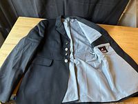 Inside view of black wool dressage jacket showing light grey satin lining and interior Euro-star label