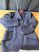 Front view of navy wool show jacket with buttons and pockets visible