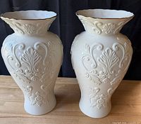 Front view of both matching ivory Lenox vases showing embossed floral design and gold-trimmed rims