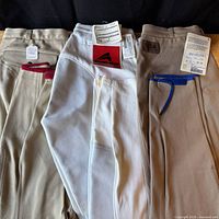 Four breeches laid out showing tags and colors beige, white, grey