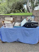 Full lot on table showing projector, trays, bulb box and stack loader