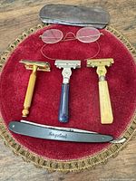 Three safety razors, Tungsteel straight razor, metal eyeglass case