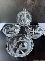 Four matching etched crystal bowls displayed together