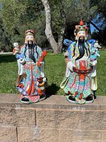 Front view showing both porcelain deity figurines outdoors