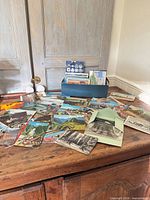 Open box on dresser with spread of assorted vintage postcards