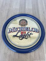 Full view of round Michelob Light mirror sign on floor