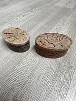 Two carved soapstone boxes closed, showing tops and sides