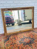 Full view of rectangular mirror leaning against wall