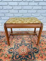 front view of wood bench showing frame, legs and upholstered seat