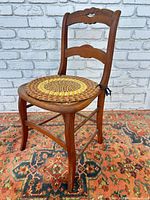 Full view of wooden chair showing frame, cane seat under pad