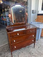 Front view of dresser with attached mirror showing overall form and finish