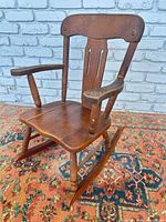 Front angled view of child’s wooden rocking chair