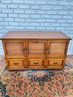 Front view of closed cedar chest showing louver panels and drawer