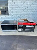 Microwave beside original box showing both items