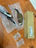 Complete set with both mirrors, hardware, and branded box on table