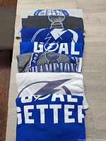 Stack of seven folded Tampa Bay Lightning shirts showing graphics and colours