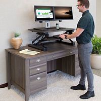 Product demonstration image showing converter on desk with dual monitors and keyboard