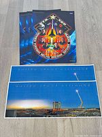 Stack of three STS-129 posters with two United Space Alliance panoramics displayed below