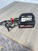 Front angled view showing charger, handle, cords, and clamps