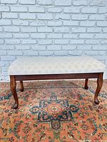 Full frontal view of bench showing fabric seat and legs