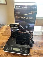 Cooktop standing in front of original box with manual visible