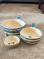 Three hand-painted ceramic bowls displayed side by side