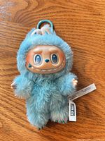 Front view of blue Labubu Monster plush keychain with tags visible