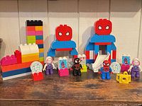 Full lot showing assembled structures, slide, camera, printed tiles, four figures and assortment of bricks