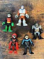 Group of five Imaginext action figures displayed on wooden surface