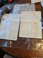 clear vinyl aprons with pockets and grommets viewed flat in packaging