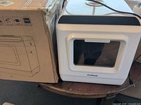 ChuMaste countertop dishwasher next to its original box, front view