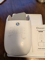 Top view of Knqze hand massager showing power button and control icons
