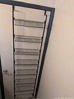 Full view of assembled black over-door rack with eight baskets