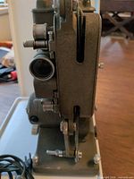 Left side view showing lens, film gate slot, drive belt and base