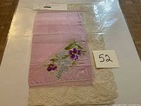 Full view of pink silk handkerchief mounted on board, lace edges visible, lot label