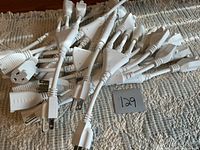 Pile of white 3-prong splitter cords showing plugs and receptacles