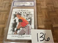 Front view of graded Jackson Holliday Leaf Rookie card in slab with lot number card visible