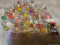 Group of capsules and bag of loose toys on fabric surface