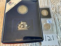 Overall lot showing 1990 limited edition boxed quarter with pewter ship plus two individual quarters in holders