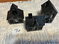 Front view of three black metal house tealight holders