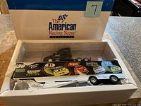 Box exterior showing The American Racing Scene branding and transporter in insert